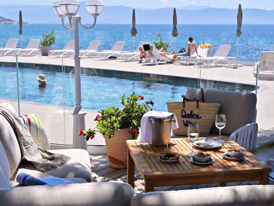 Una piscina al aire libre, sillones reclinables de piscina