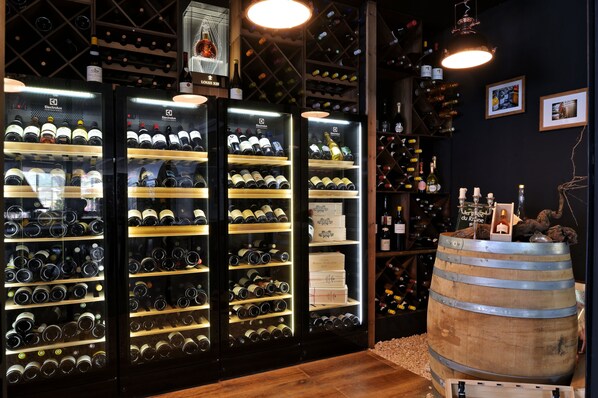 Una cava de vinos con múltiples estanterías y un barril de madera.