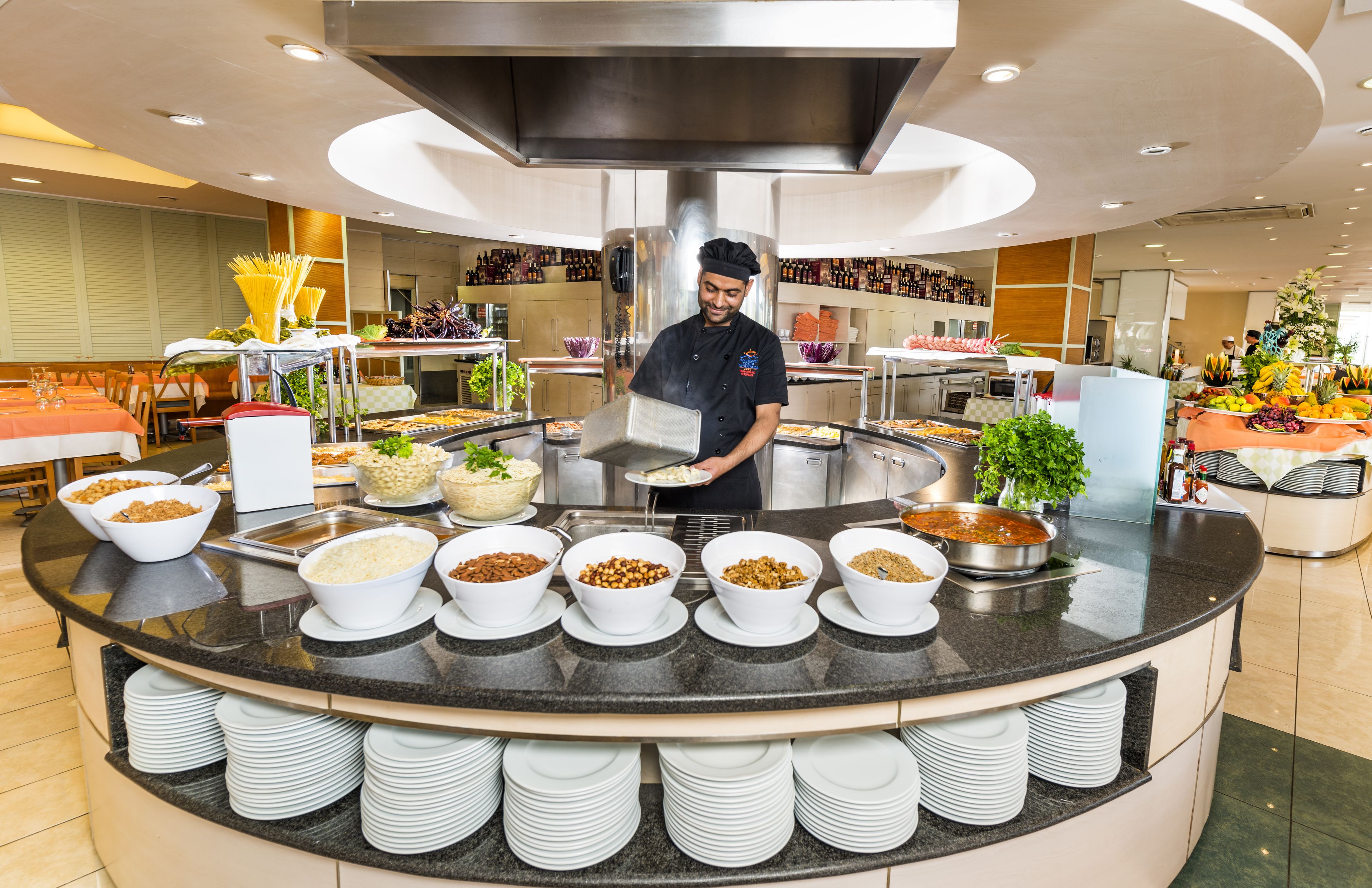Un buffet con diverse pietanze e uno chef che serve.