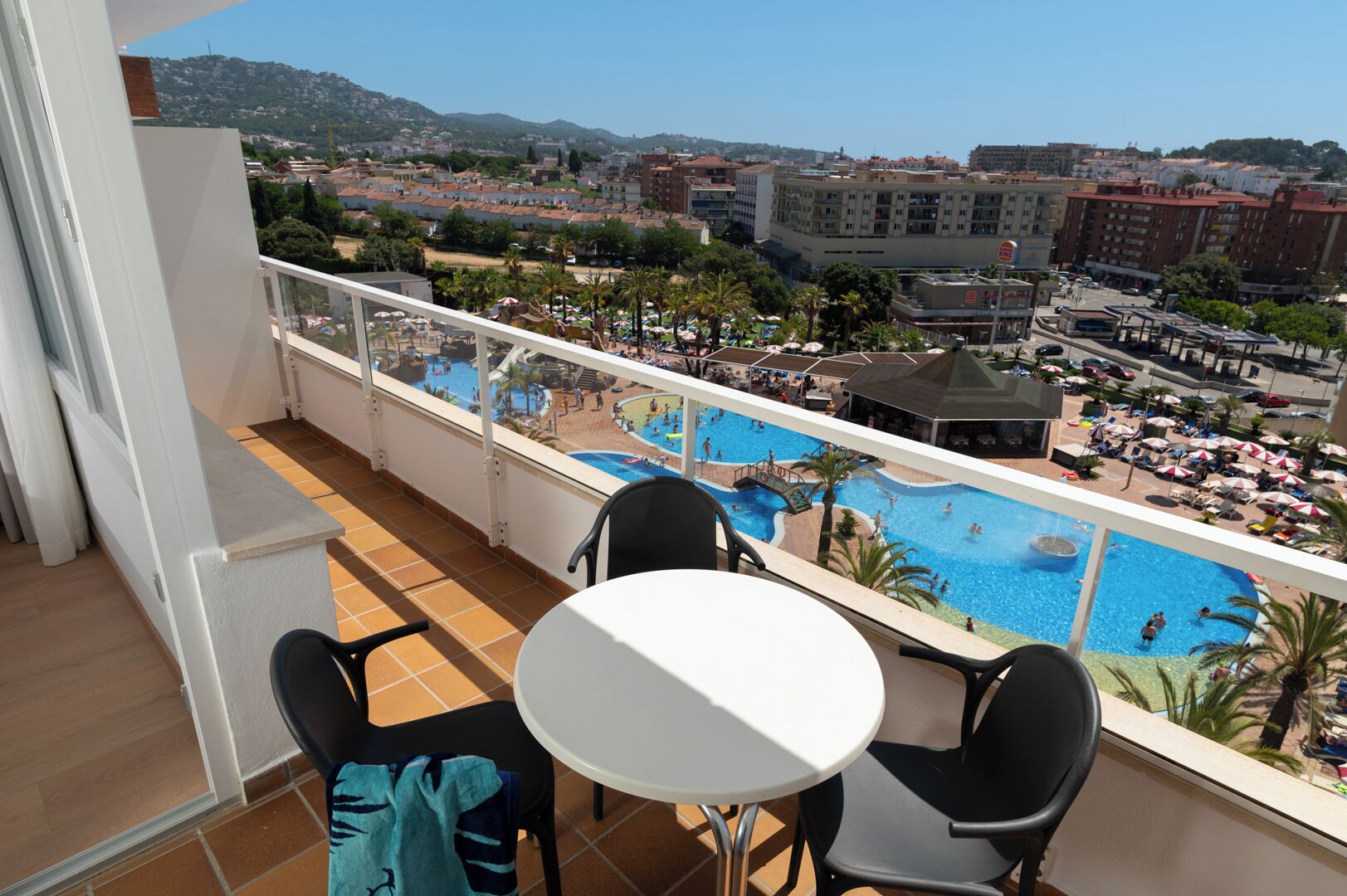 Ein Balkon mit Blick auf Poolanlage und Resort, inklusive Tisch und Stühlen.