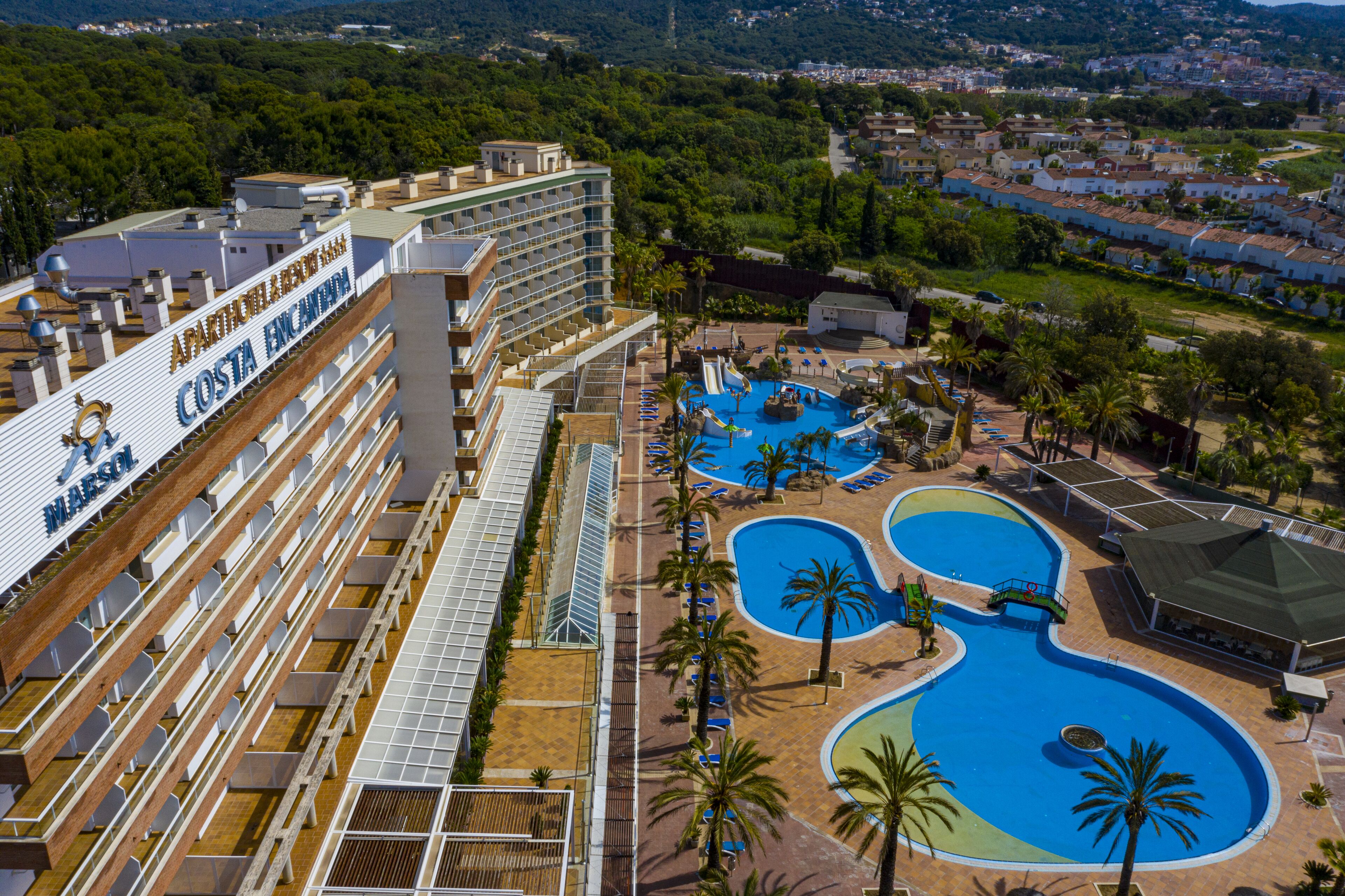 Een binnenzwembad, een buitenzwembad, parasols voor strand/zwembad