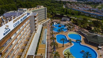 Een binnenzwembad, een buitenzwembad, parasols voor strand/zwembad