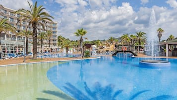 Una piscina techada, una piscina al aire libre, sombrillas