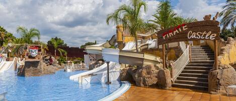 A pool area with a pirate-themed sign, slides, and a staircase leading to a higher platform.