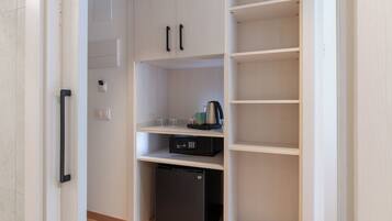 Una cocina equipada con lavavajillas, cafetera y un refrigerador pequeño.