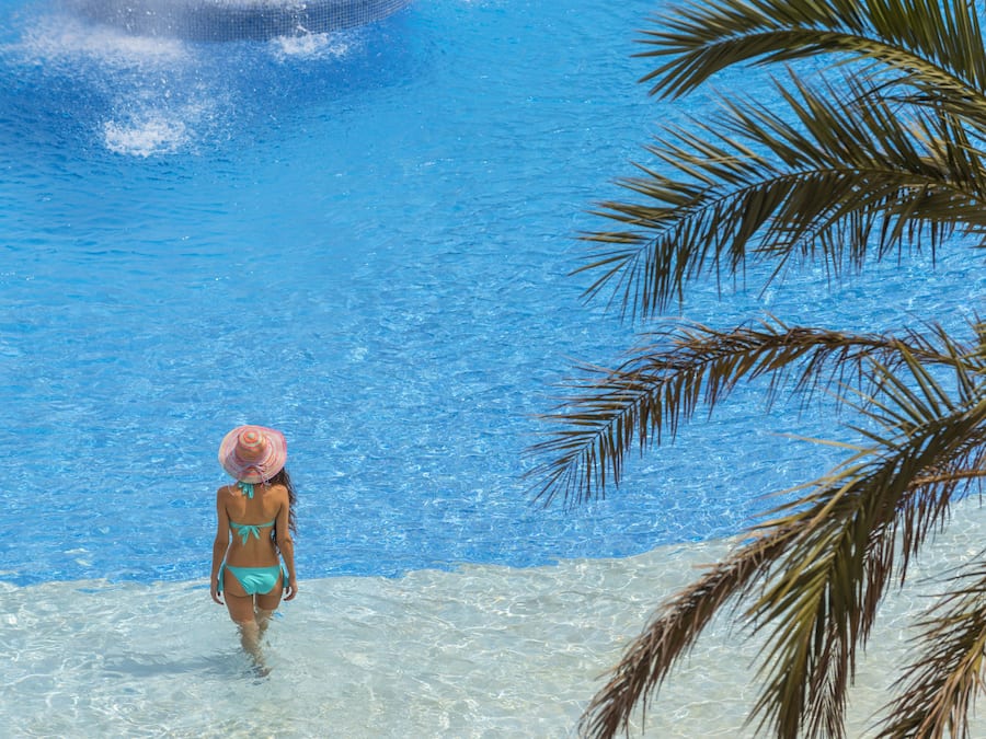 Una piscina cubierta, una piscina al aire libre, sombrillas, tumbonas