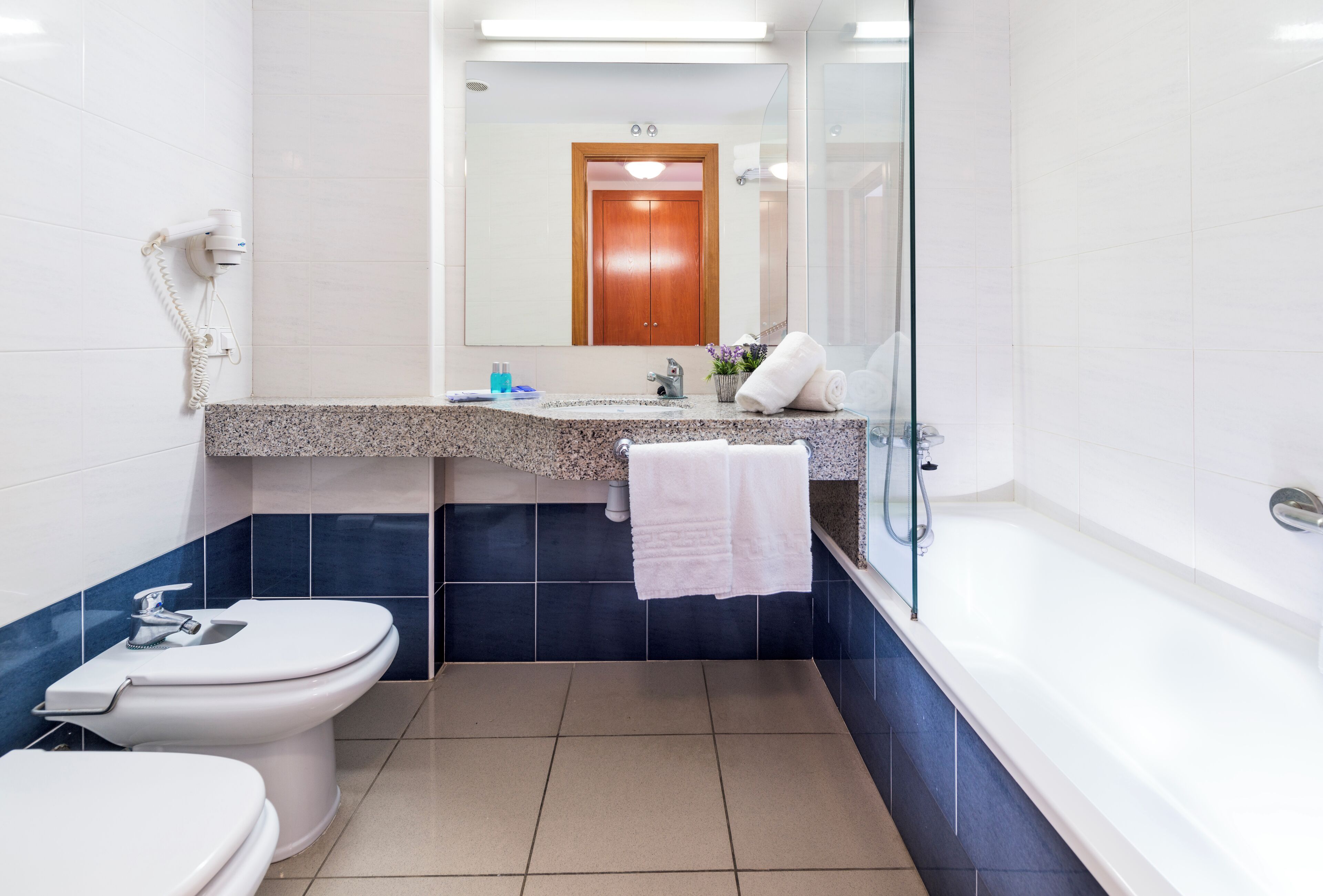 A modern bathroom with a toilet, sink, and bathtub.