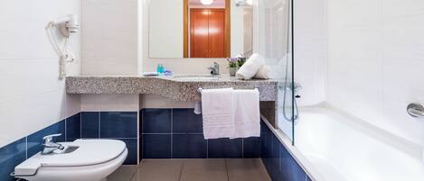 A modern bathroom with a toilet, sink, and bathtub.