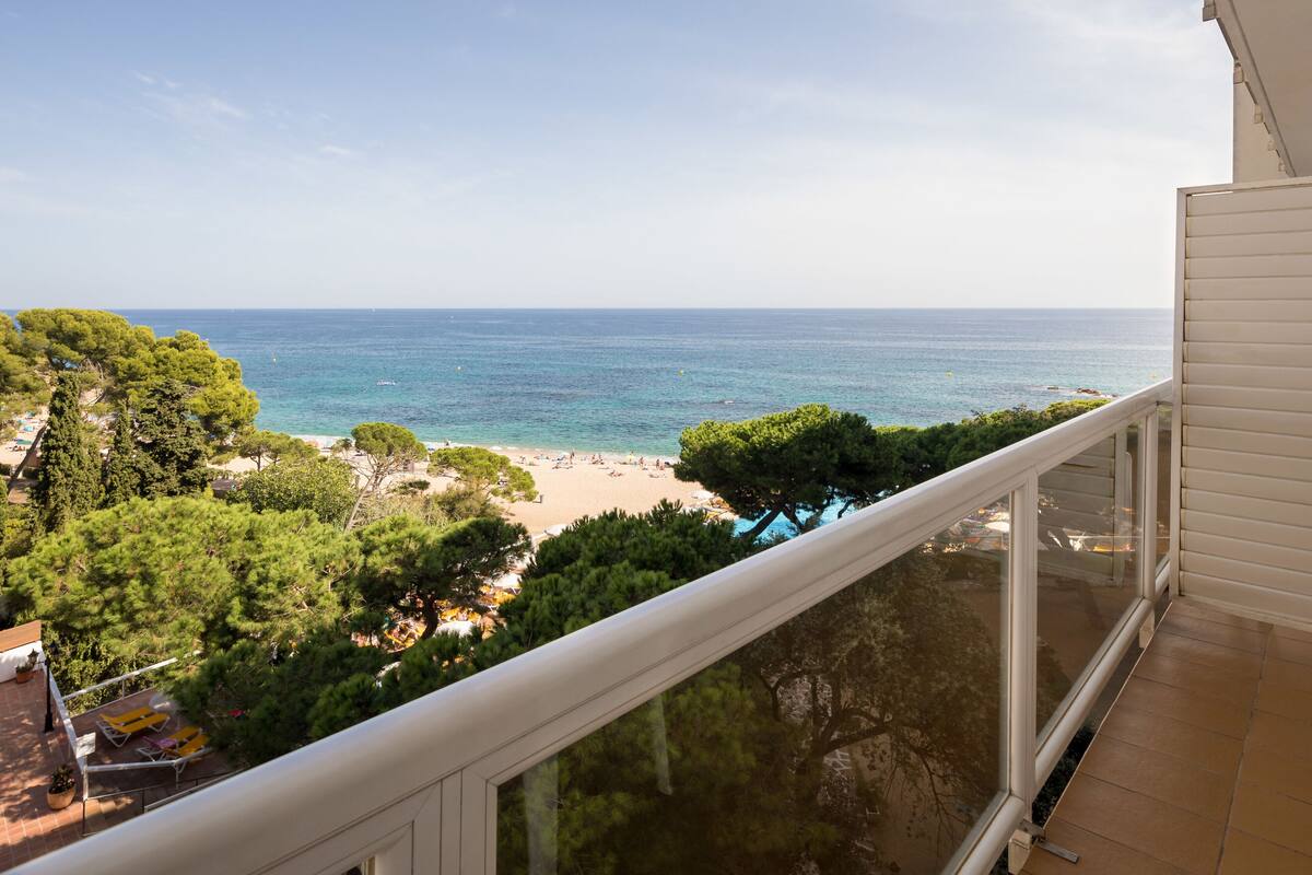 A balcony with a view of a beach and ocean.