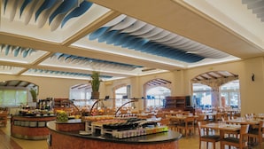 Ein großzügiger Speisebereich mit einer zentralen Buffettheke, verschiedenen Sitzgelegenheiten und einem markanten Deckenstil.