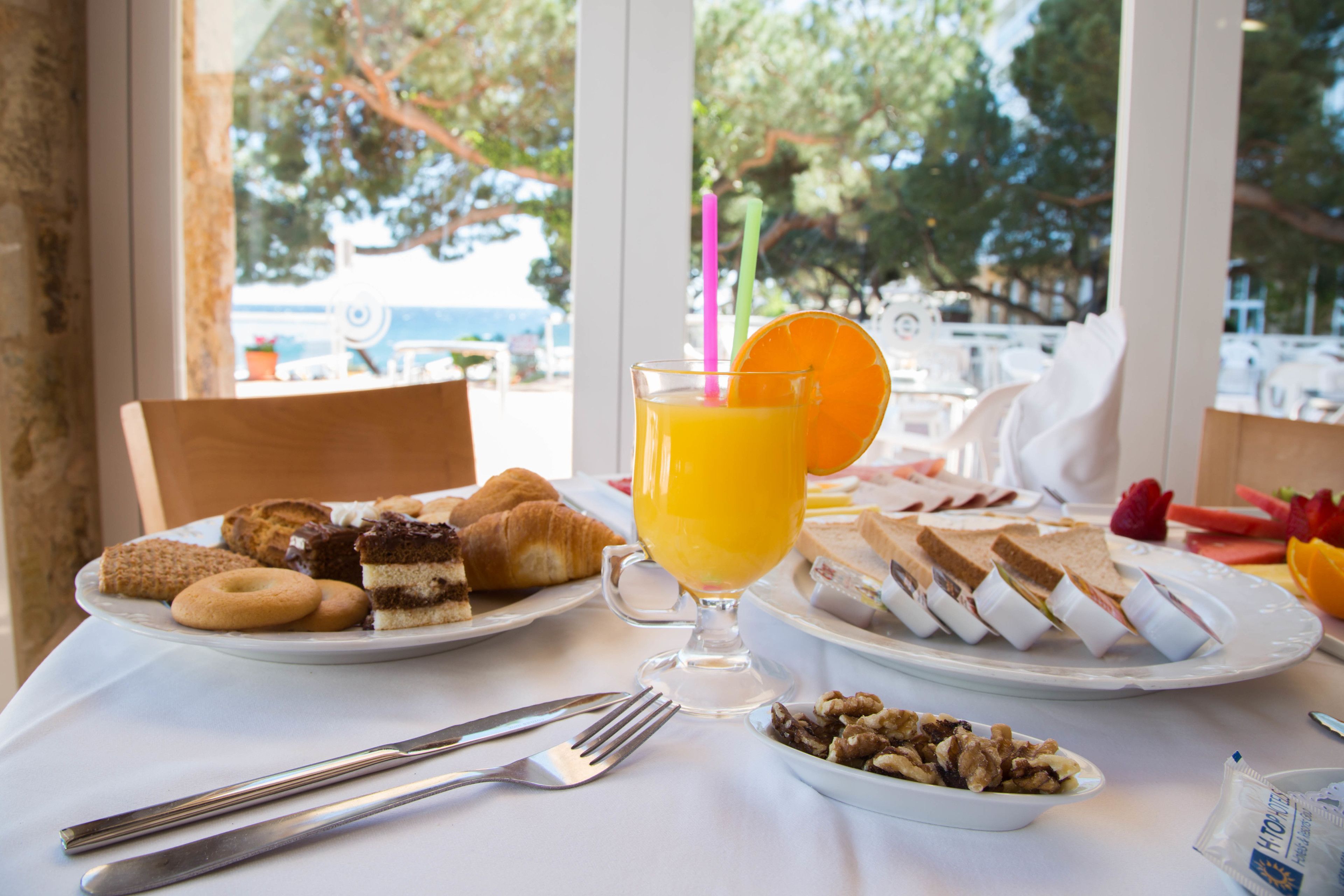 Ein Frühstückstisch mit Croissants, Gebäck und einem Glas Orangensaft.