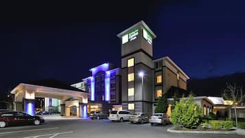 A Holiday Inn Express & Suites hotel with a parking lot and several cars parked in front.