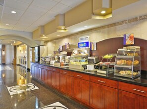 Zona de desayuno de hotel con mostrador de buffet, estación de café y un letrero que indica el servicio Express Start.