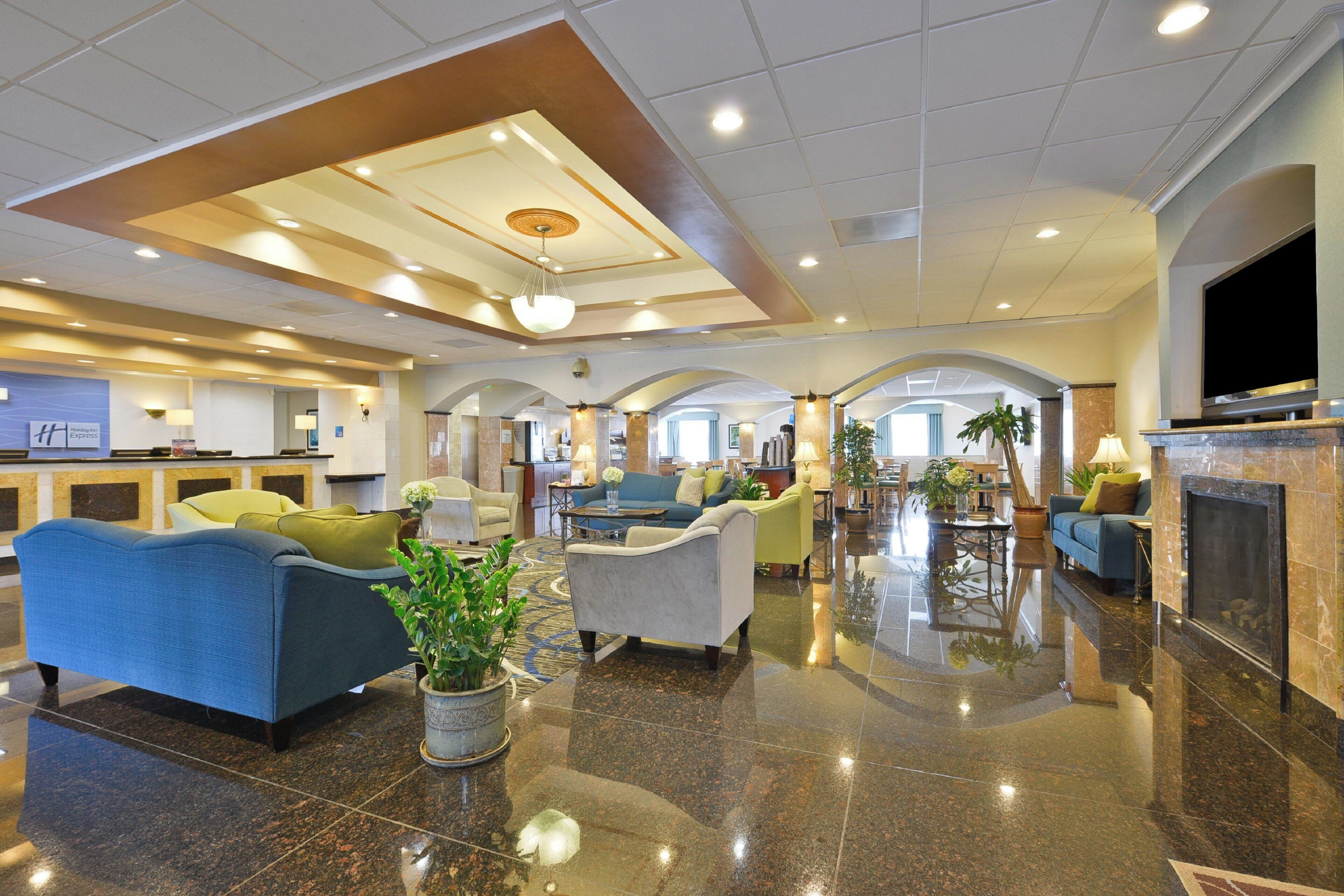 A spacious lobby with multiple seating areas, a reception desk, and a fireplace.