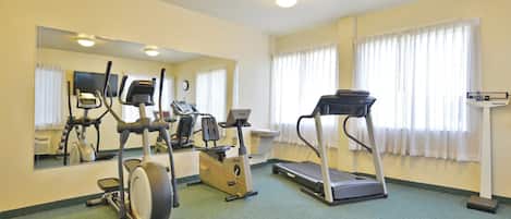 A fitness room with exercise equipment including treadmills, an elliptical, and a stationary bike.