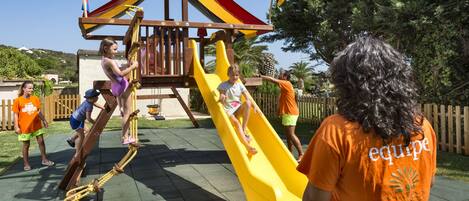 Un parque infantil con un tobogán y estructuras para escalar.