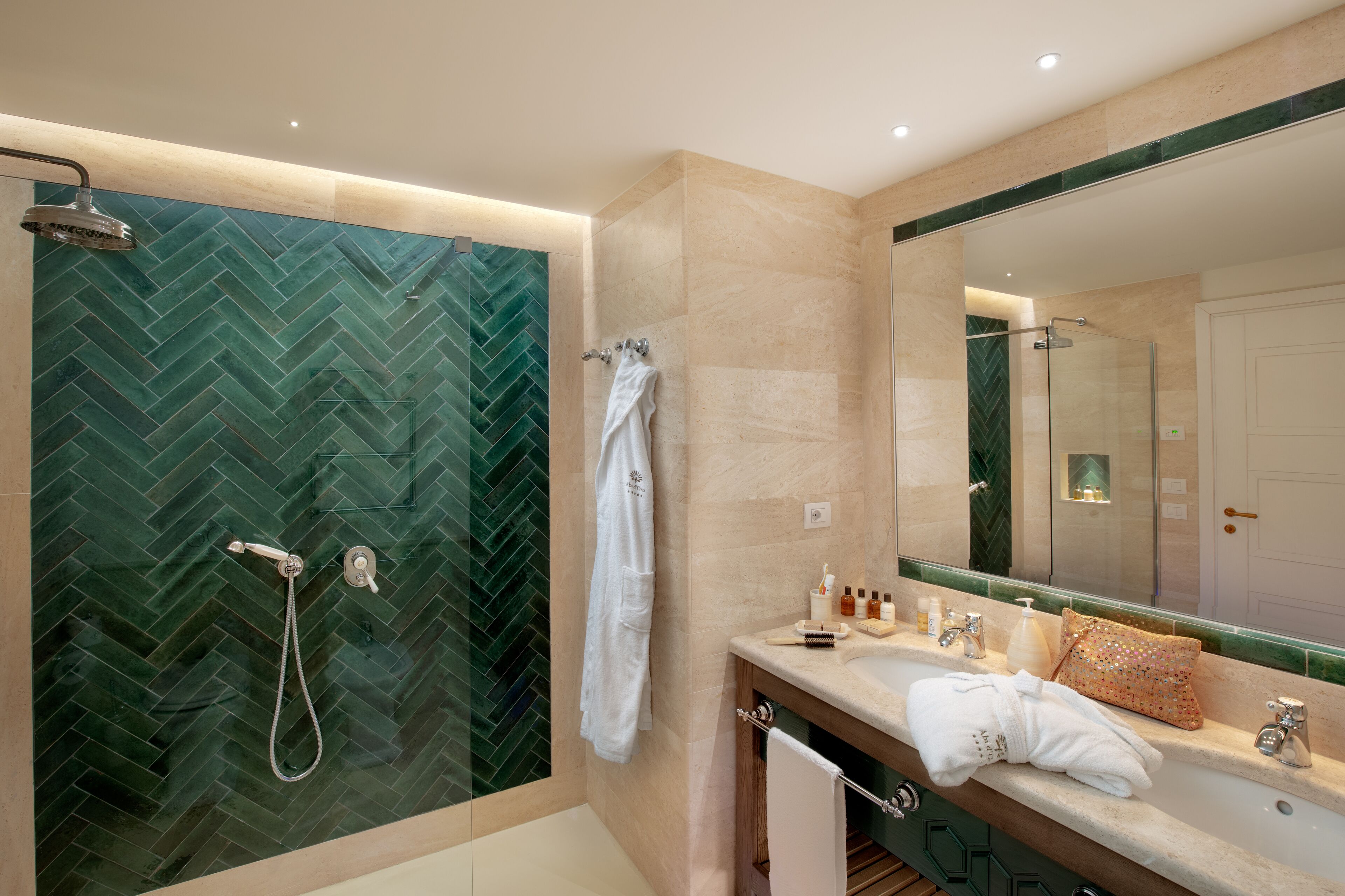 A modern bathroom with a herringbone tile shower, a vanity with a mirror, and a towel rack.