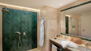 A modern bathroom with a herringbone tile shower, a vanity with a mirror, and a towel rack.