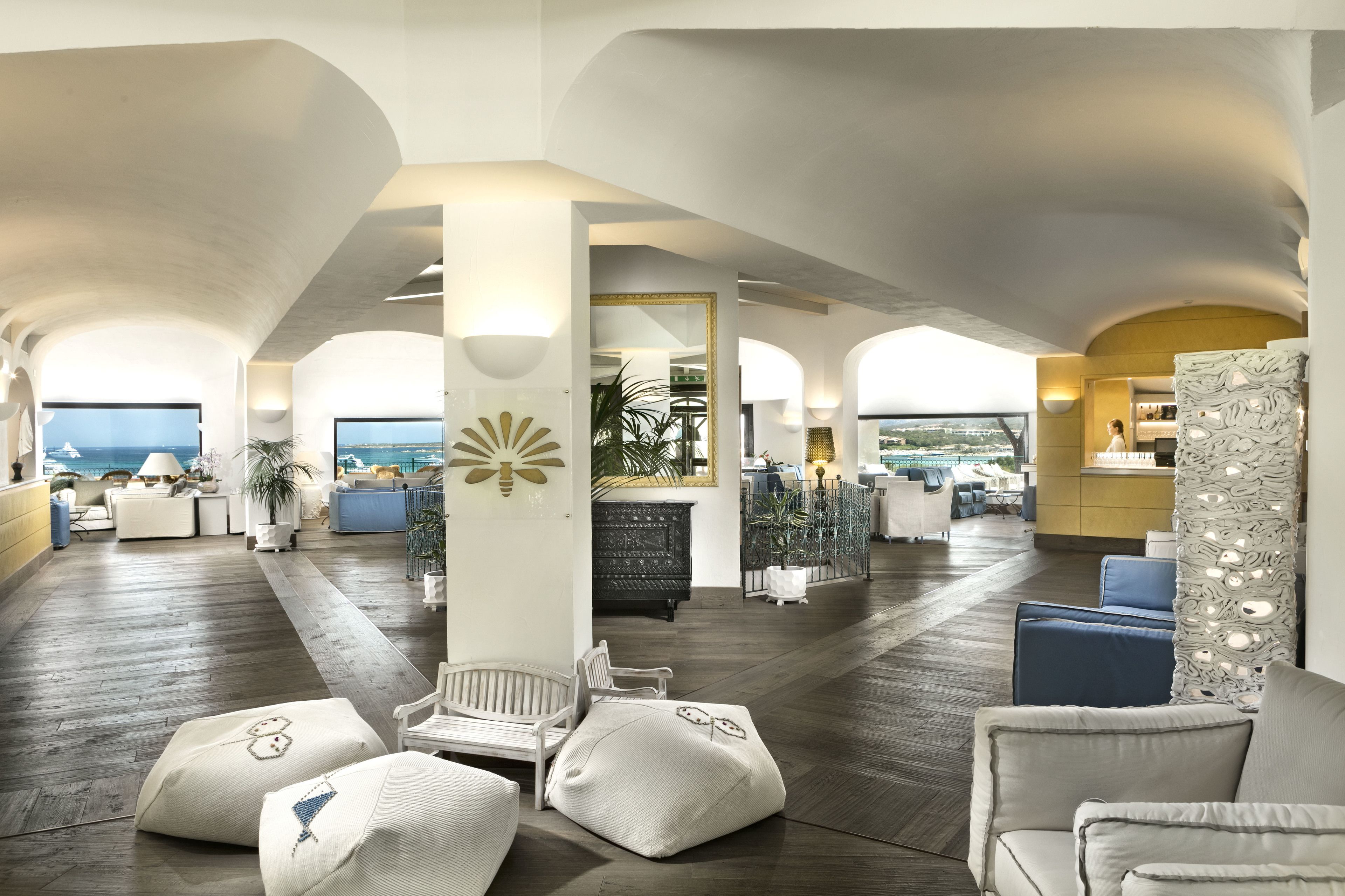 A spacious lobby with high ceilings, a central seating area, and a view of the ocean.