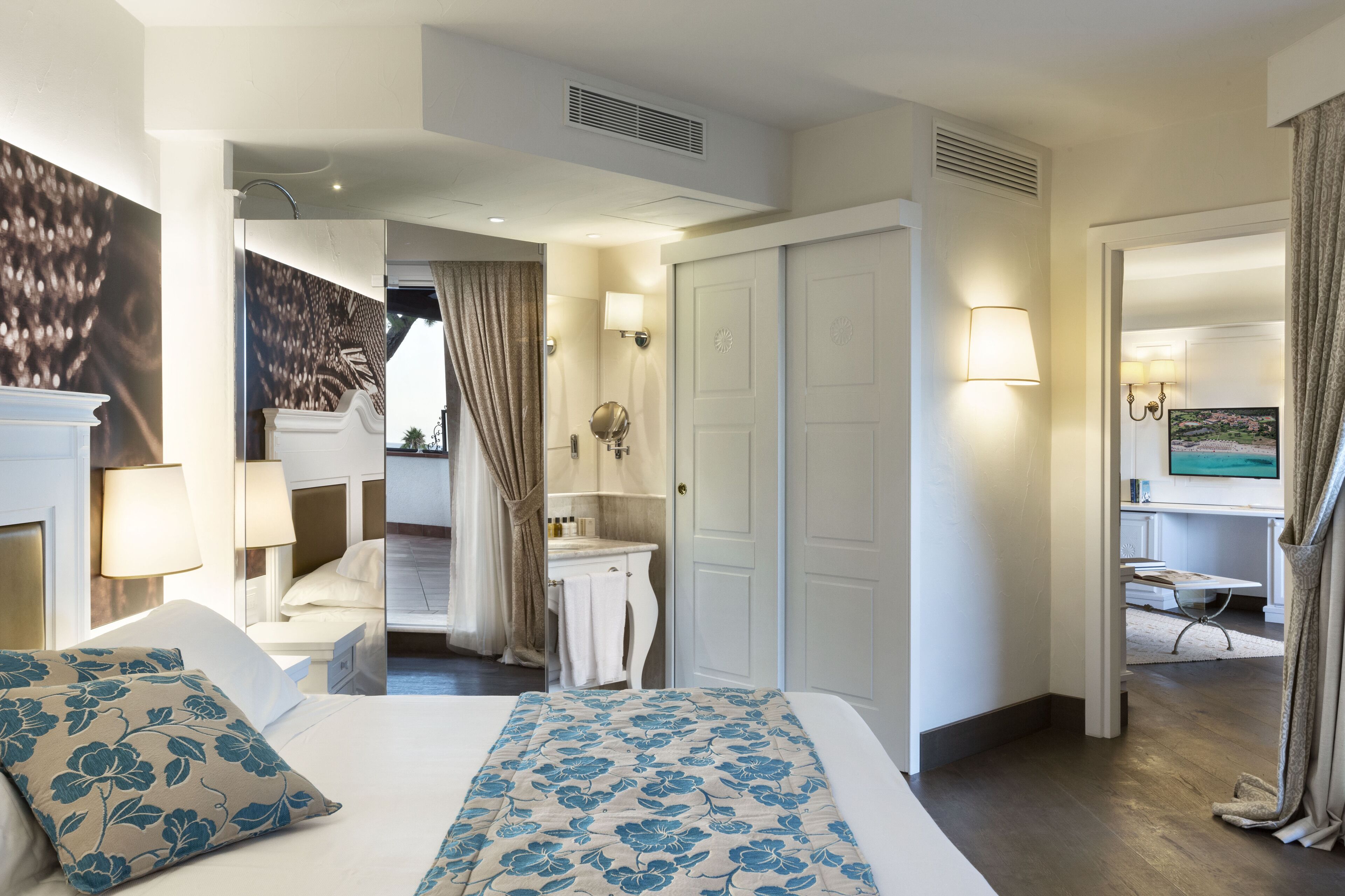 A hotel room with a bed, a bathroom, and a desk area.