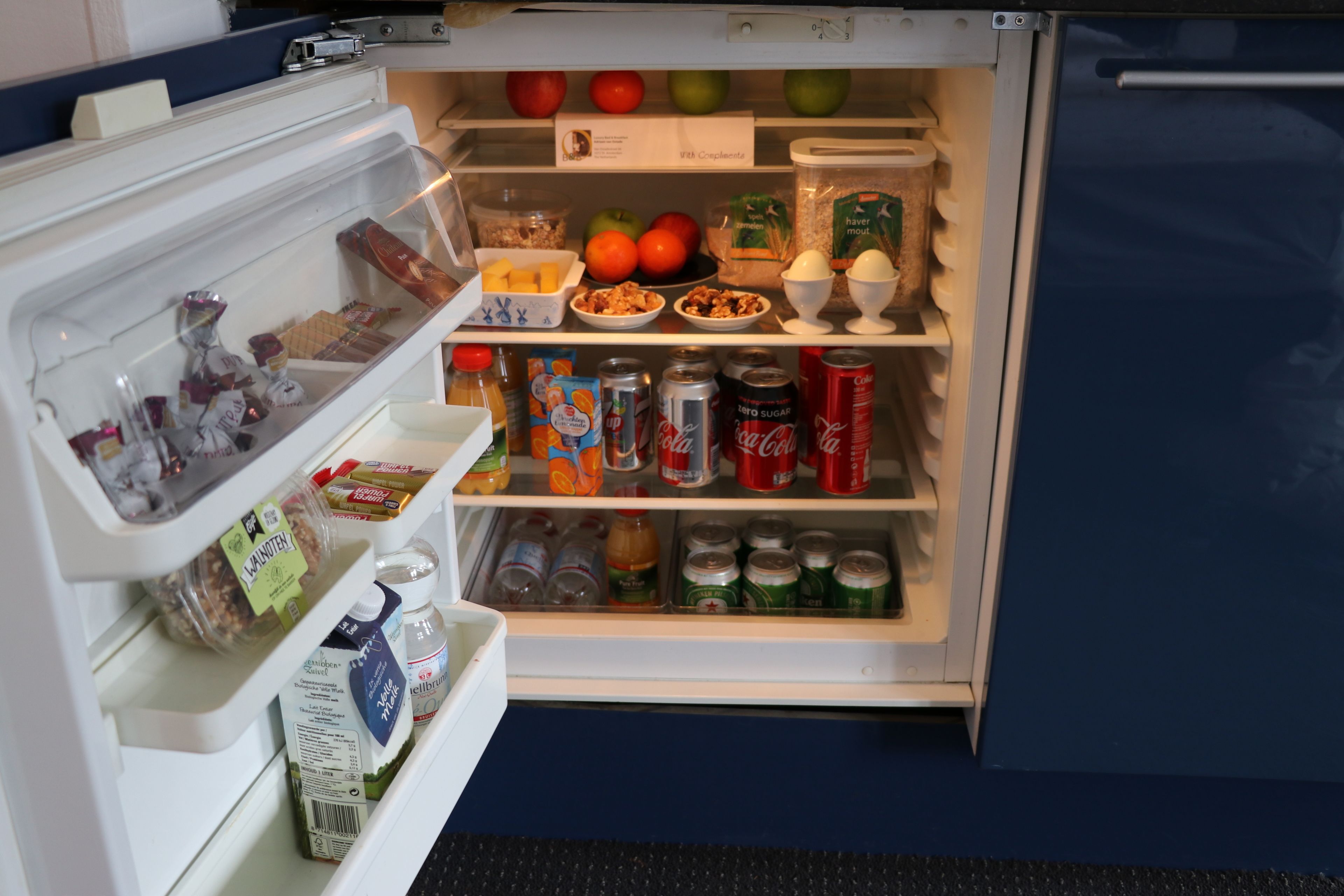 An open refrigerator with various food items and beverages.