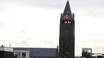 Un campanario con techo puntiagudo y un diseño a cuadros cerca de la parte superior.