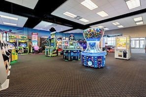 A gaming arcade with various machines, carpeted floor, and ceiling lights. - Canad Inns Destination Center Grand Forks (Grand Forks)