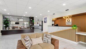 A modern hotel lobby with a reception desk, a sofa, and a reception area with a wooden panel design. - Quality Inn Wytheville (Wytheville)