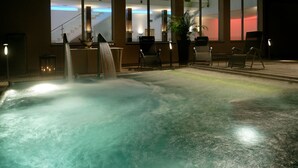 Un área de spa con hidromasaje, asientos y vistas del interior del edificio.
