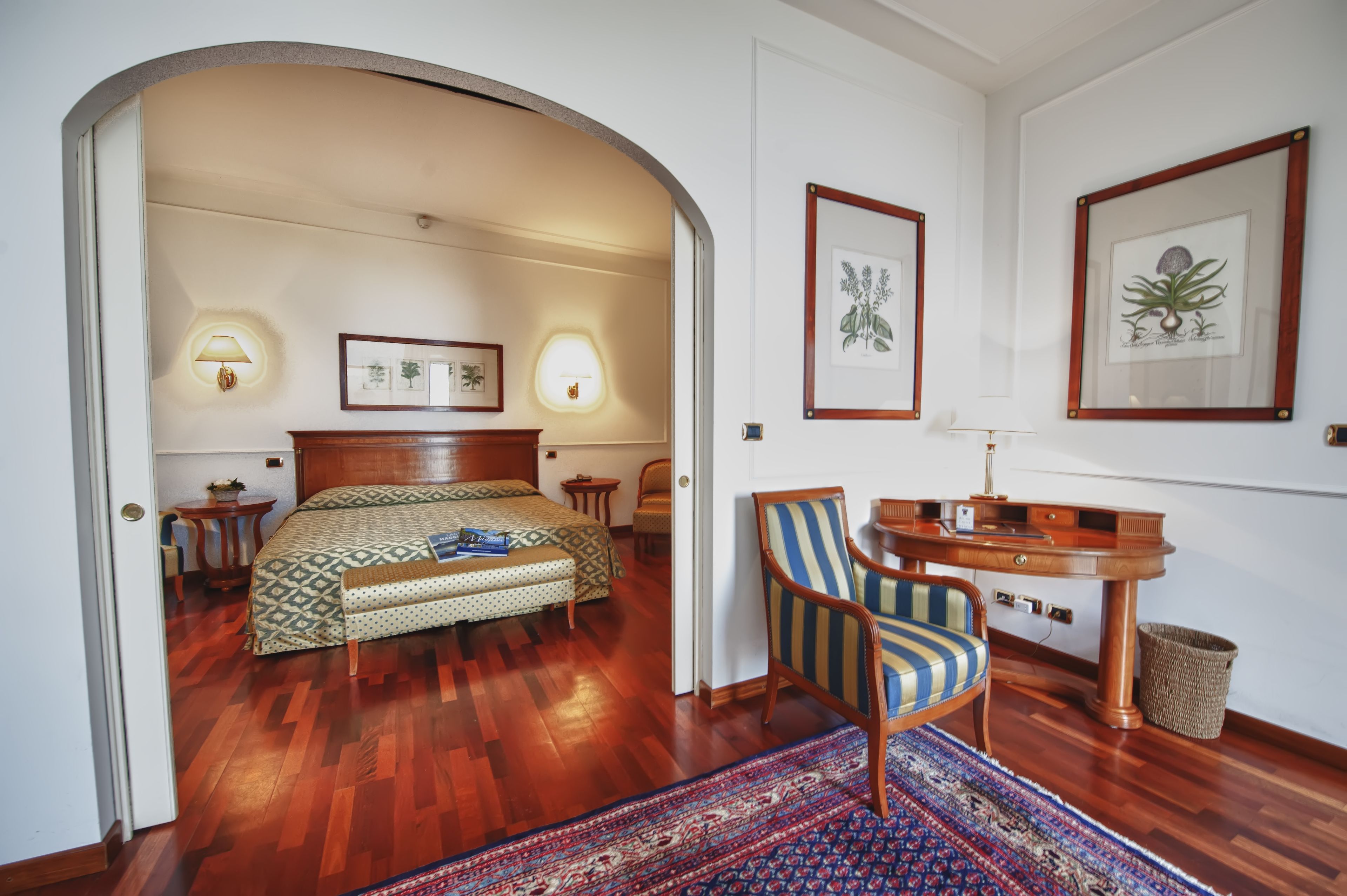 Una habitación con cama, escritorio, silla y alfombra.