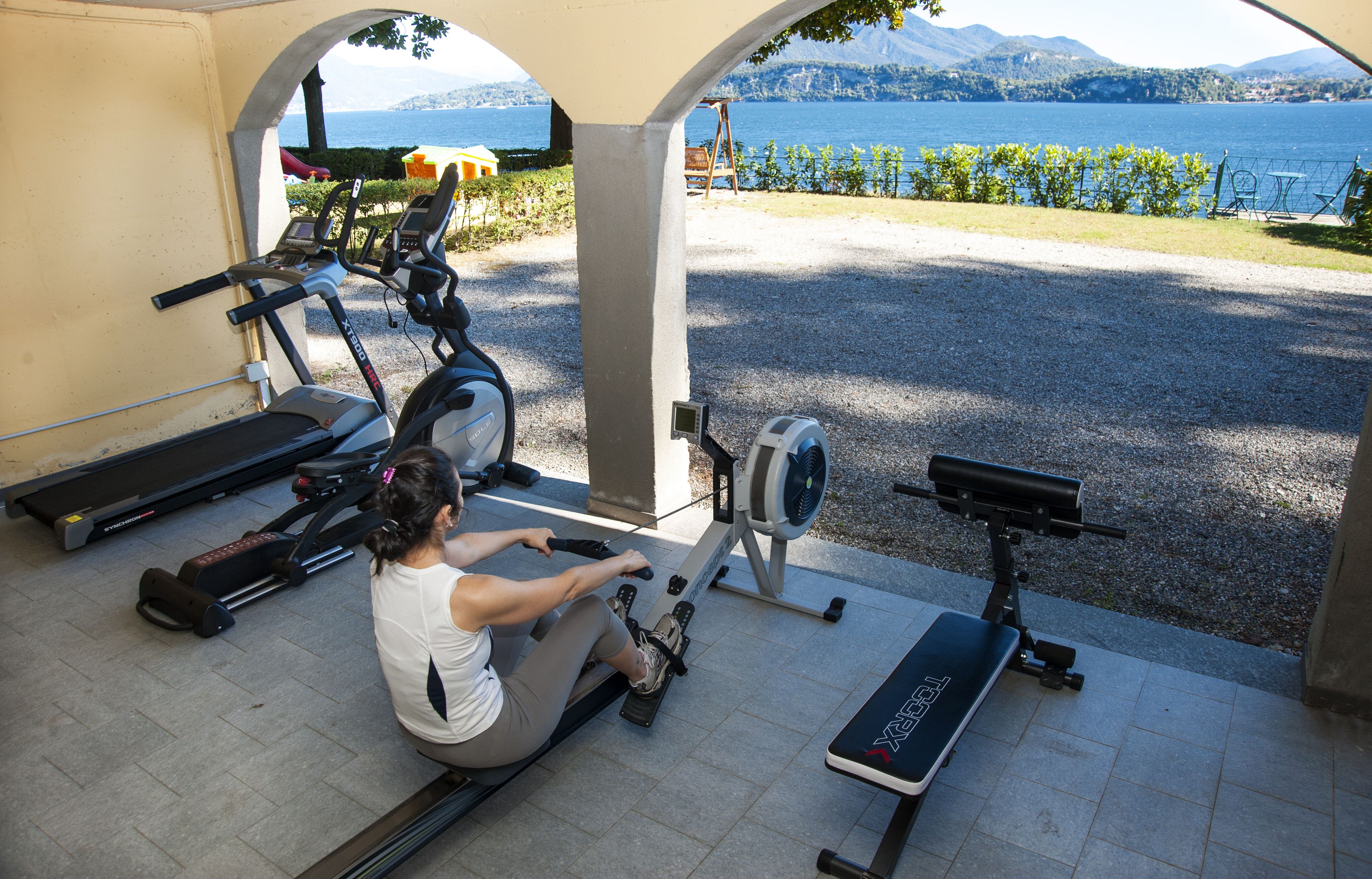 A gym with exercise equipment including a rowing machine, a stationary bike, and a treadmill.