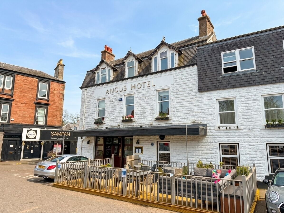 A white building with a sign reading 'Angus Hotel' and a visible entrance.