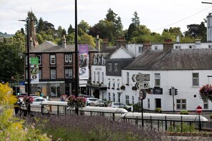 A traditional white building with a sign for 'Tourist Information Centre' and a 'Give Way' sign. - The Angus Hotel & Spa by Compass Hospitality (Blairgowrie)