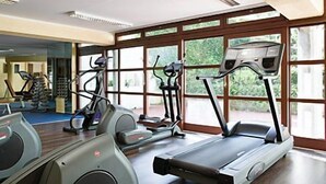 Un gimnasio con cintas de correr, elípticas y bicicletas estáticas.