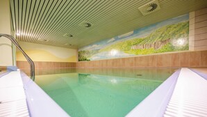 A swimming pool with a mural of a landscape on the wall behind it. - Hotel Sportwelt (Radeberg)