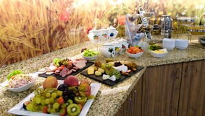 A buffet spread with various fruits, cheeses, and meats. - Hotel Sportwelt (Radeberg)