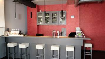 A bar area with a counter, stools, and a display cabinet.