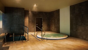 A spa room with a hot tub, a staircase, and a door leading to another area.