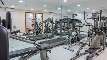 A gym with various cardio machines, mirrors, and a clean, modern design.