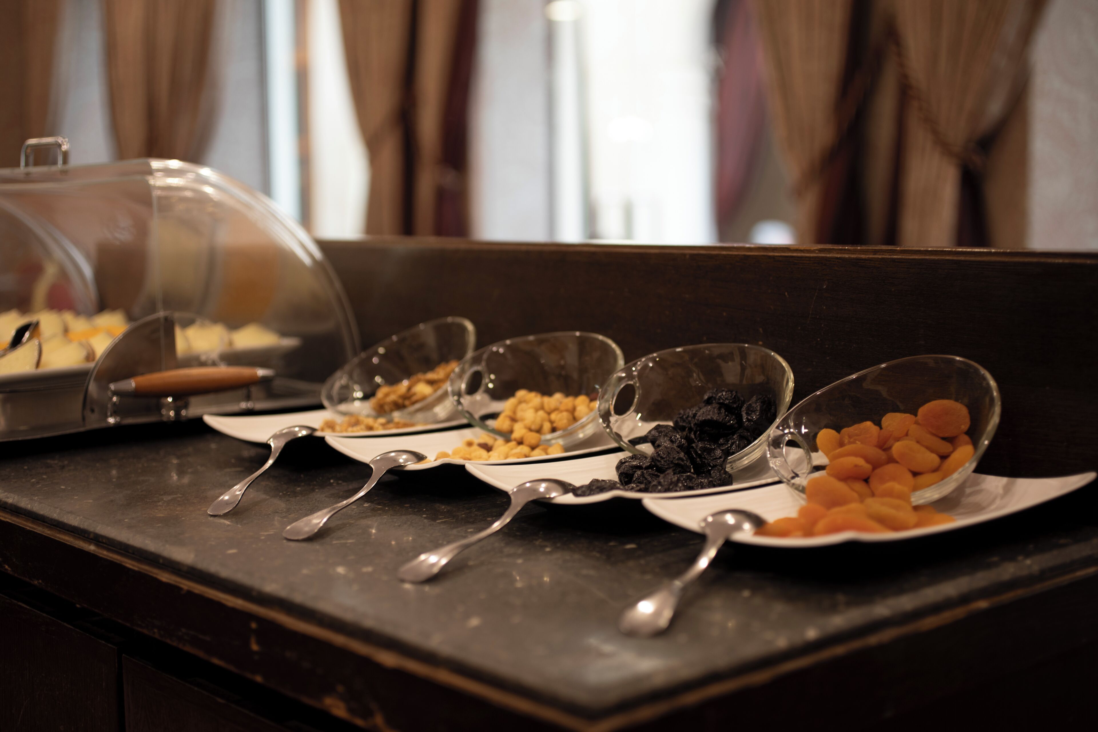 Una mesa de buffet con diversos alimentos y utensilios de servicio.