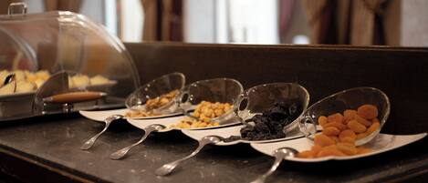 Una mesa de buffet con diversos alimentos y utensilios de servicio.