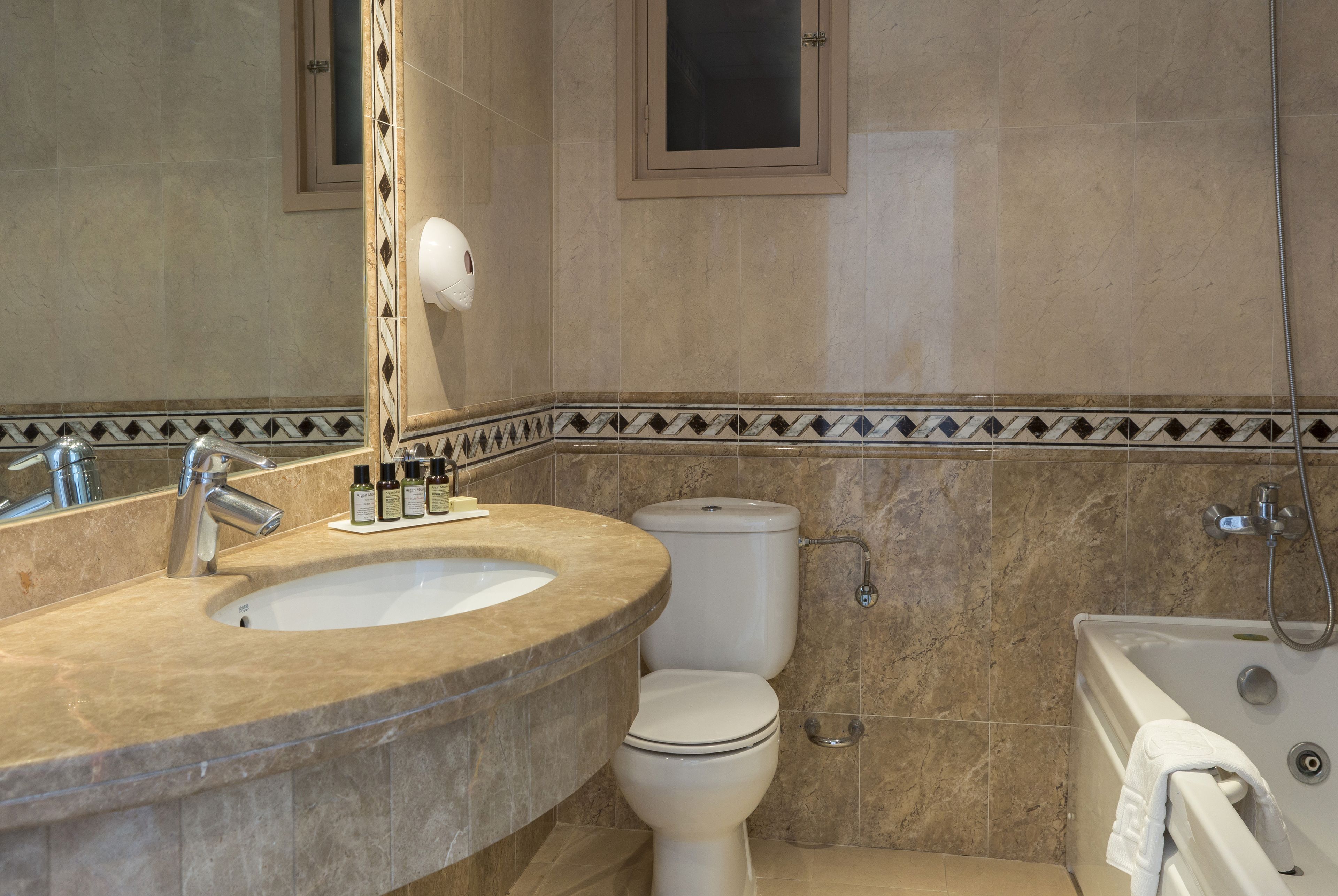Un baño con lavamanos, inodoro y bañera.