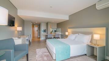 Ein modernes Hotelzimmer mit einem großen Bett, Nachttischen, einem Schreibtisch und einem Sessel.