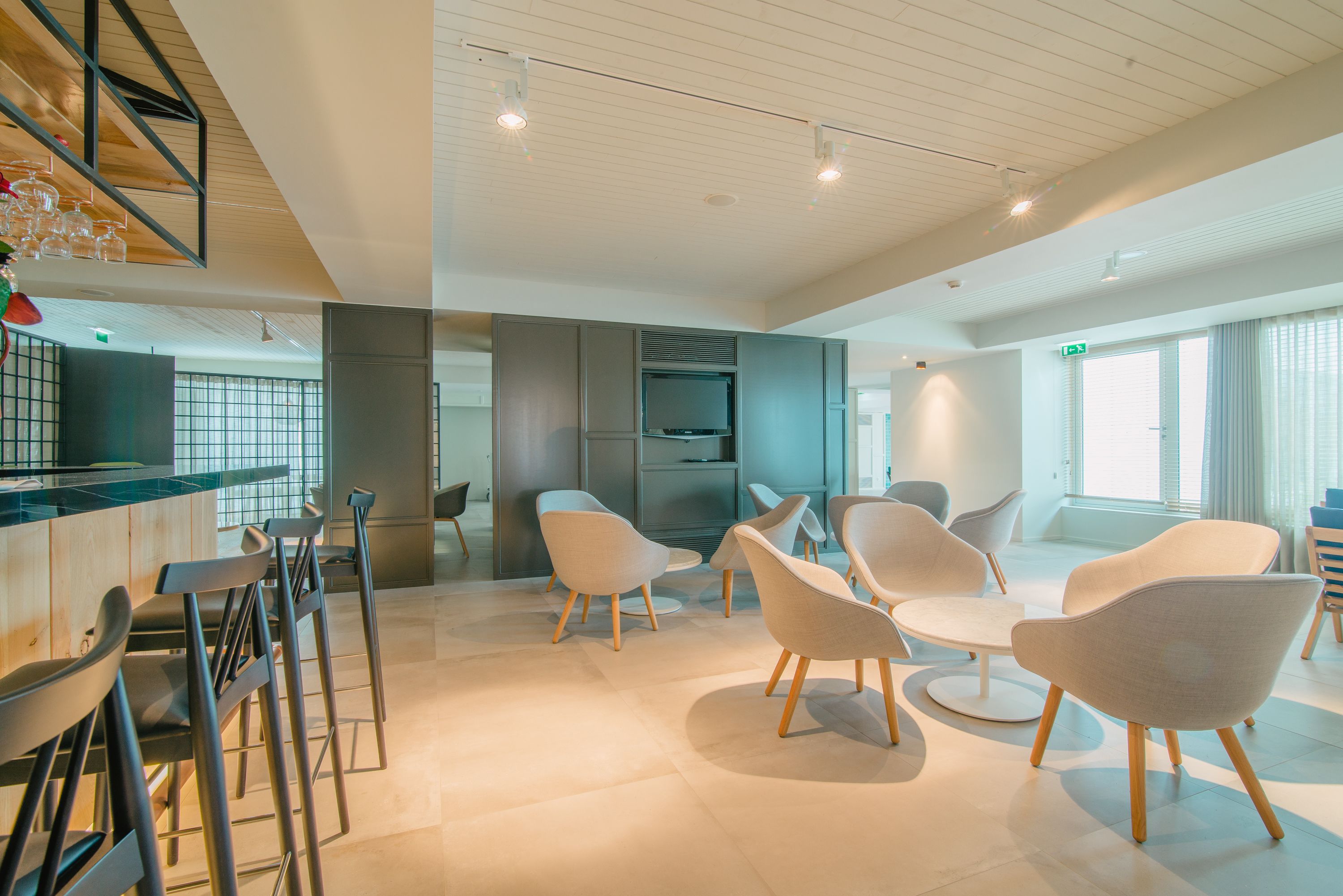 A modern interior with a bar area, seating, and a television.