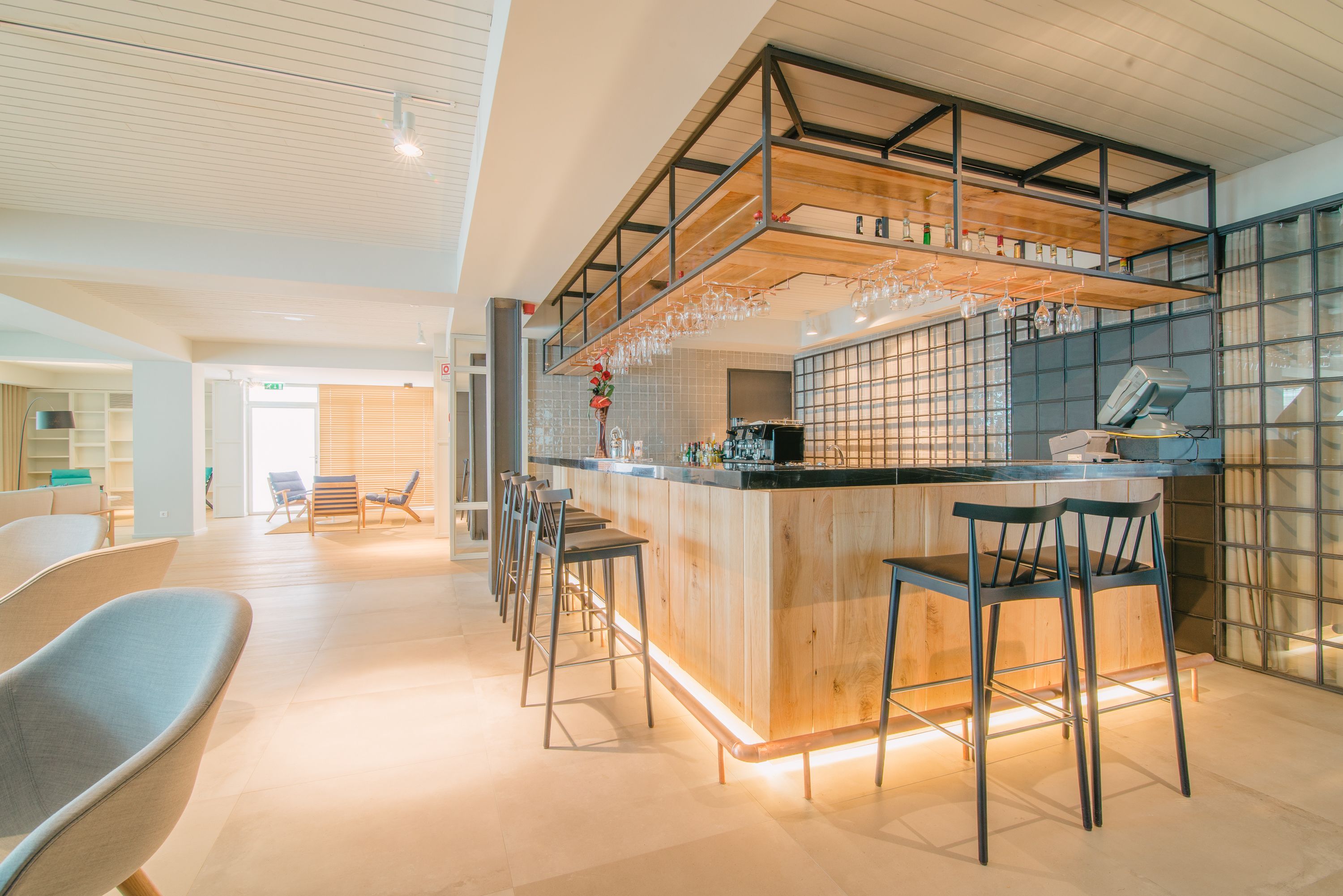 Eine moderne Bar mit einer Holztresore, Barhocker und einer Glasvitrine.