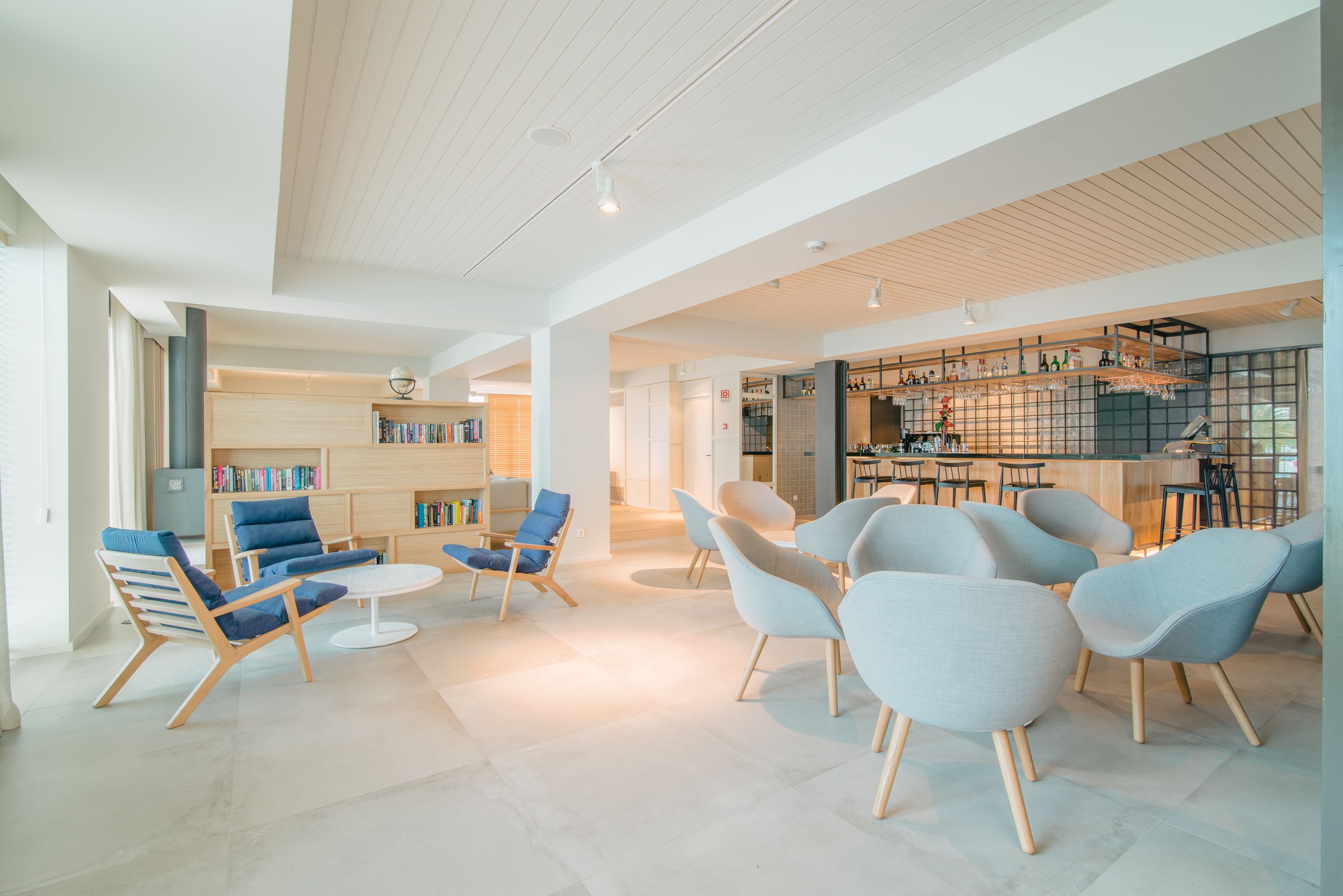 A spacious lobby with modern seating, a bar area, and a library.