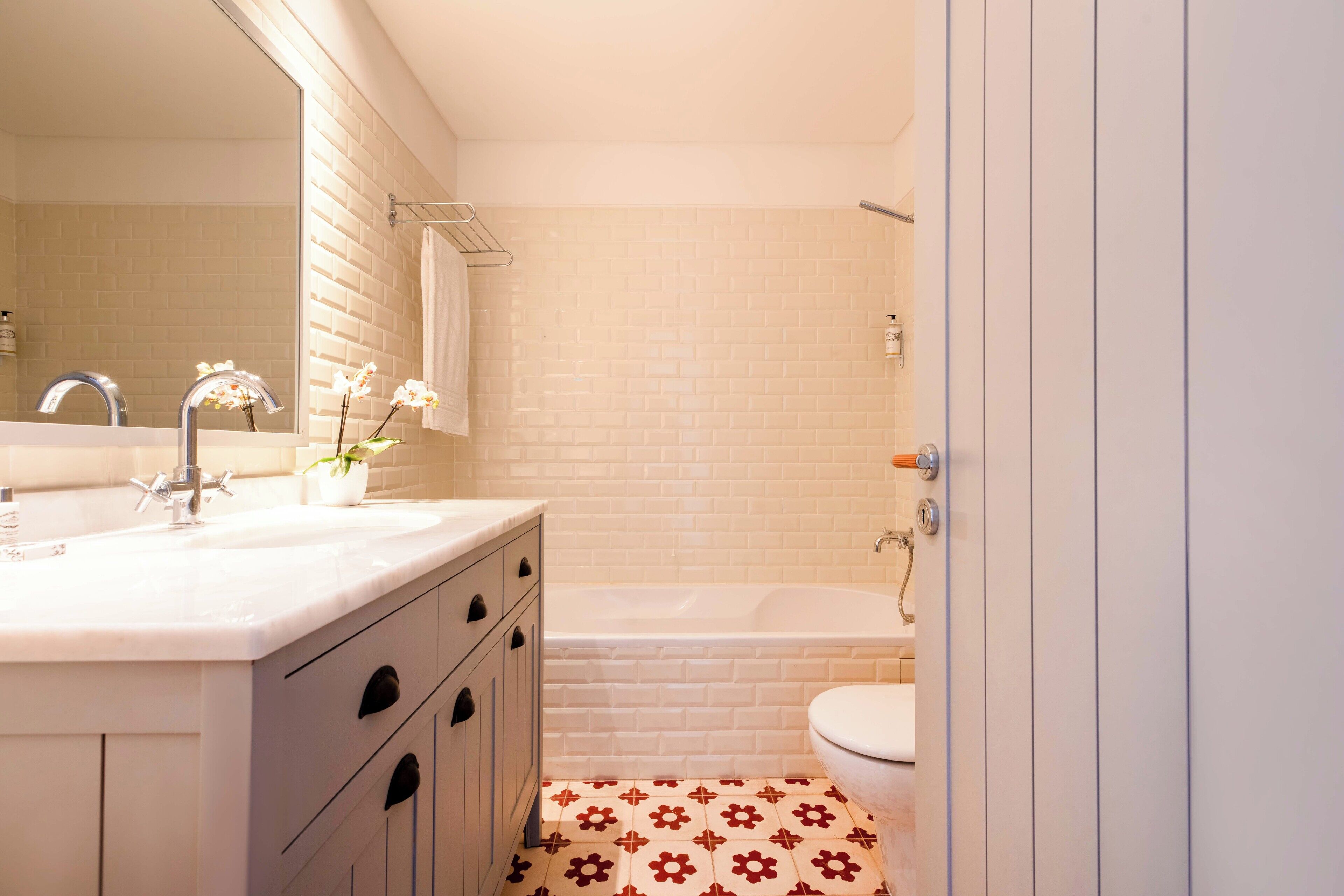 A bathroom with a white sink, mirror, and a bathtub.