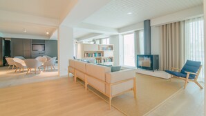 A modern living room with a sofa, chairs, a fireplace, and a bookshelf. - Aqualuz Lagos by The Editory (Lagos)