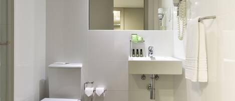 Ein modernes Badezimmer mit Toilette, Waschbecken und Spiegel.