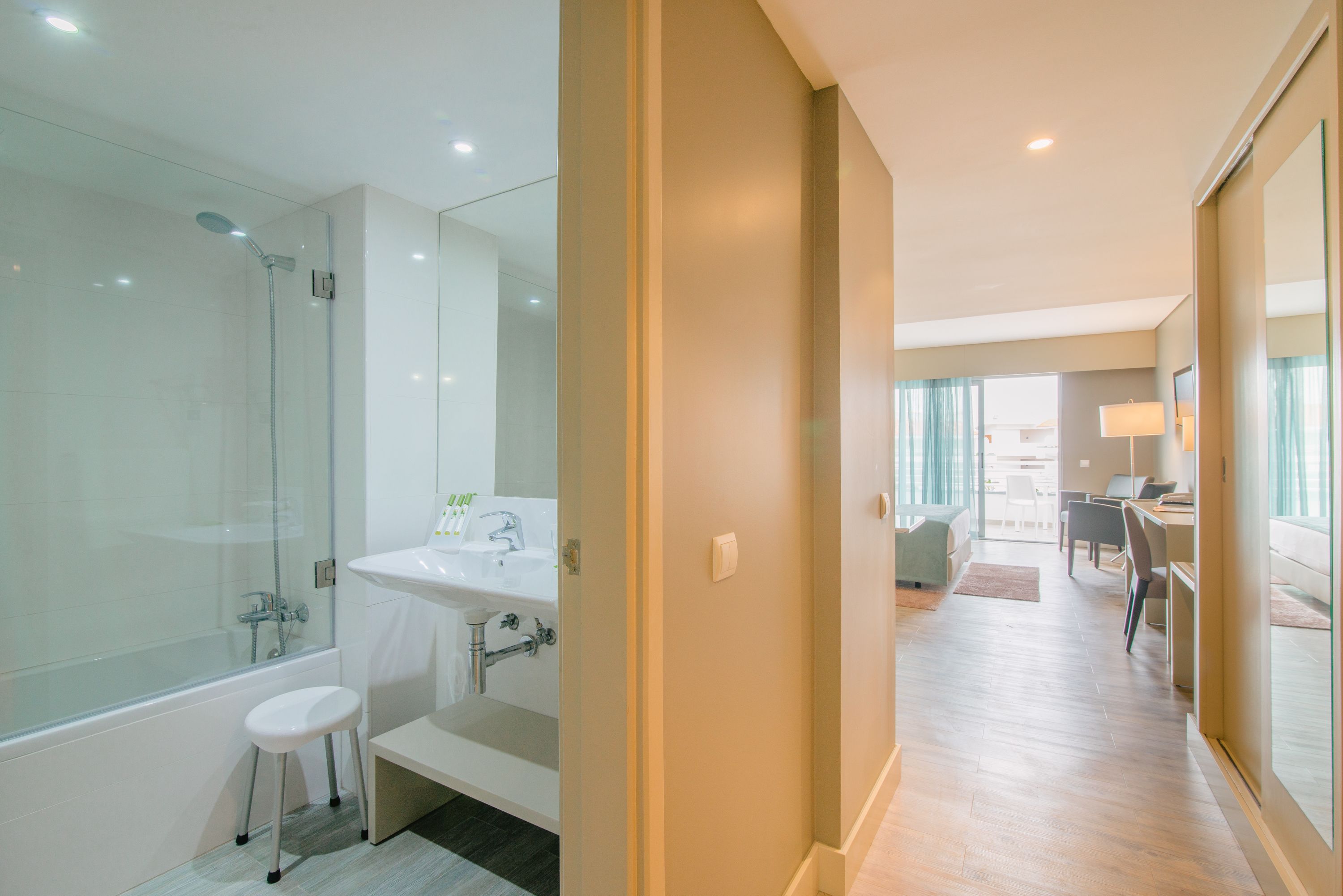 Une salle de bain moderne avec une douche en verre, un lavabo et un banc.
